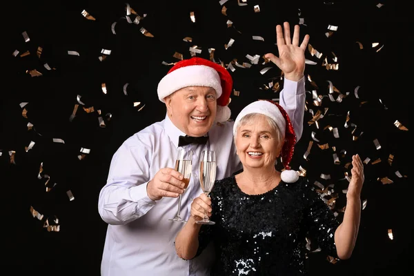 Пожилая Пара Шампанским Празднует Рождество Тёмном Фоне — стоковое фото