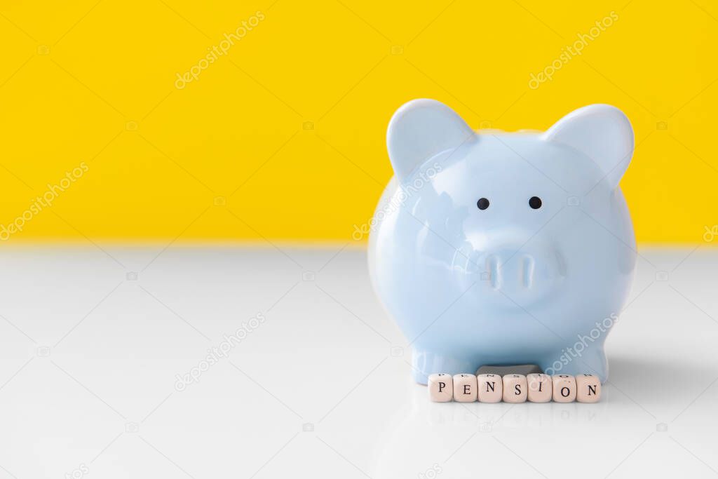 Piggy bank with word PENSION on table