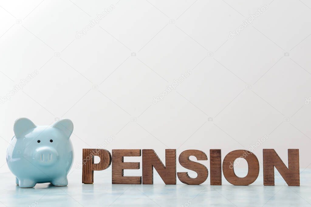 Piggy bank with word PENSION on light background