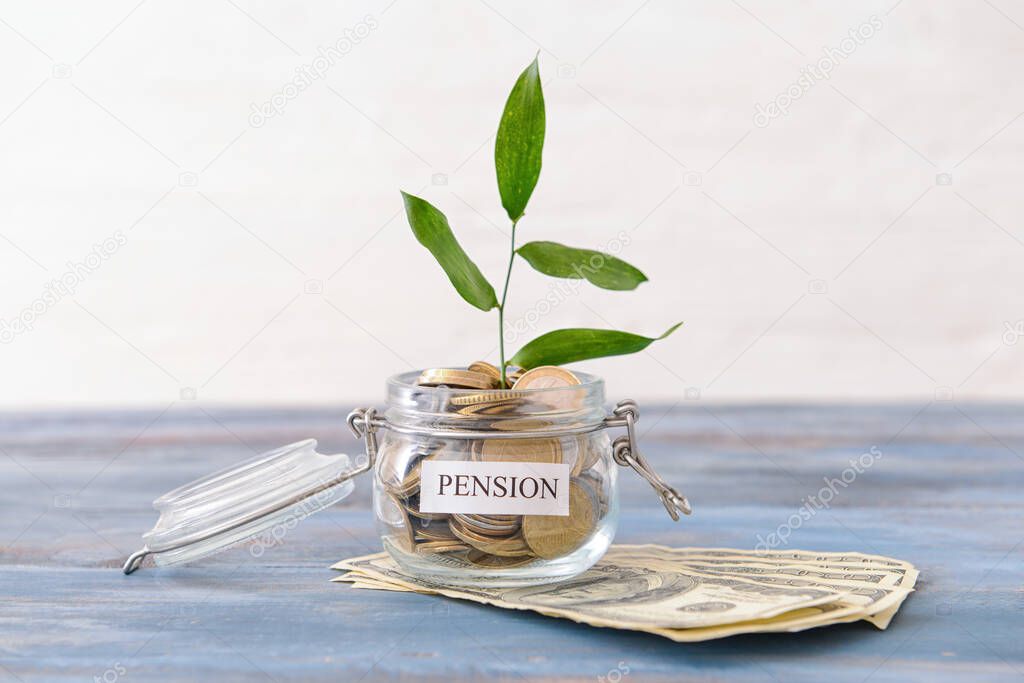 Jar with money and young plant on table. Concept of pension