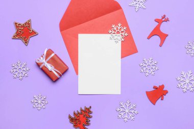 Renk arkaplanı üzerinde boş kart ve zarf olan güzel Noel süslemeleri