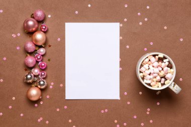 Boş kartla güzel Noel süsleri ve renkli arka planda bir fincan kakao içeceği.