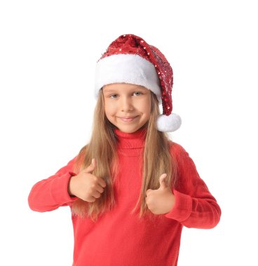 Noel Baba şapkalı şirin küçük kız beyaz arka planda baş parmak hareketi gösteriyor.