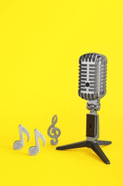 Renk arkaplanı üzerine notaları olan Retro mikrofon