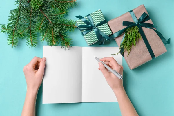 Γυναικεία Χέρια Λευκή Κάρτα Και Χριστουγεννιάτικα Δώρα Στο Φόντο Χρώμα — Φωτογραφία Αρχείου