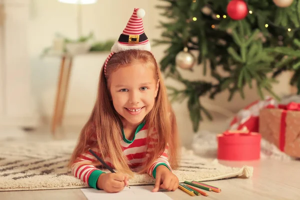 かわいいです女の子ライティング手紙にサンタクロースにクリスマス前夜に自宅 — ストック写真