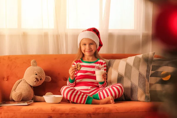 可愛いです女の子飲料ミルクとともにクッキーホームオンクリスマスEve — ストック写真