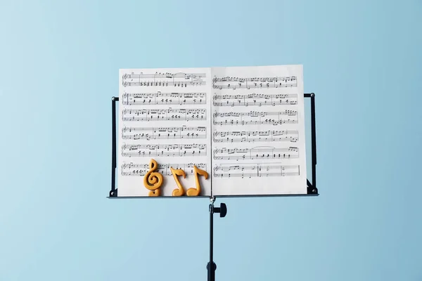 Music sheets with notes on stand against color background