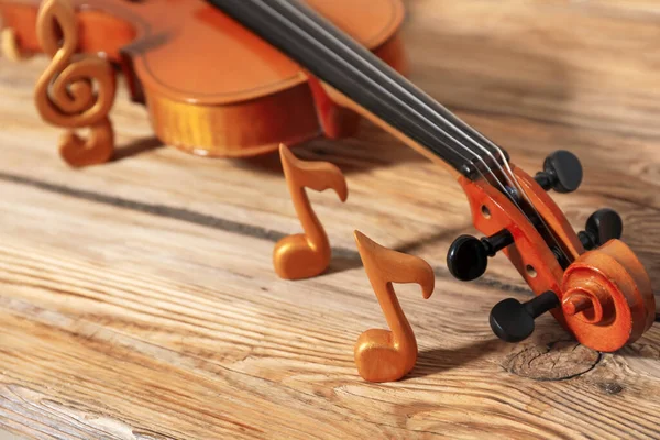 Violin with music notes on table
