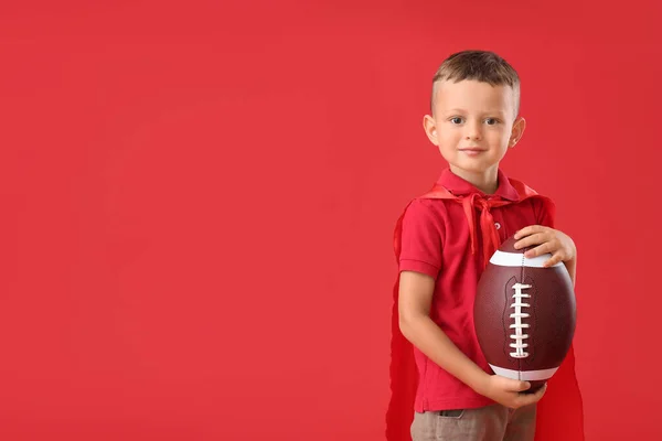 Kleiner Junge Mit Rugby Ball Und Umhang Auf Farbigem Hintergrund — Stockfoto