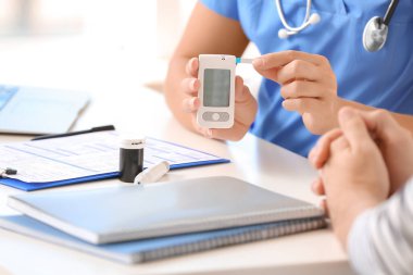 Diyabetli adam klinikte doktoru ziyaret ediyor.