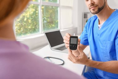 Diyabetli kadın klinikte doktoru ziyaret ediyor.