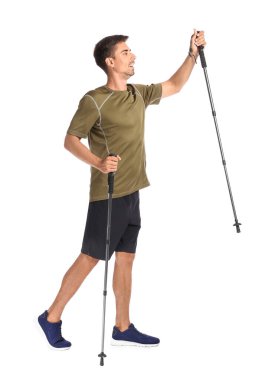 Beyaz arka planda bastonları olan genç bir adam.