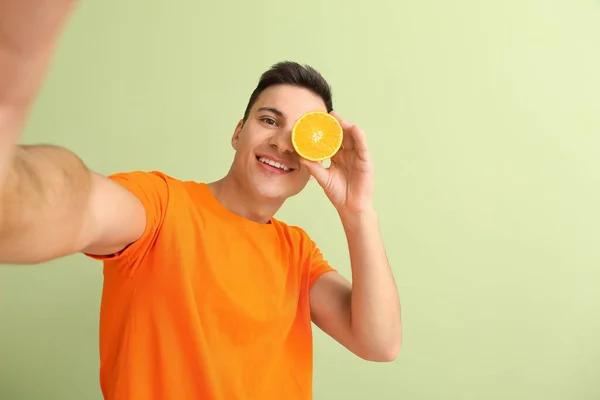 Knappe Man Met Rijp Oranje Nemen Selfie Kleur Achtergrond — Stockfoto