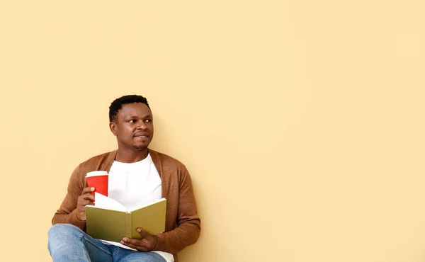 African American Man Coffee Reading Book Color Background — Stock Photo, Image