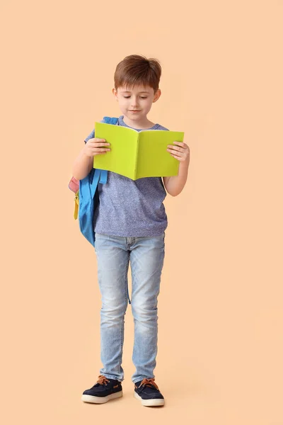 Kleiner Schuljunge Mit Notizbuch Auf Farbigem Hintergrund — Stockfoto