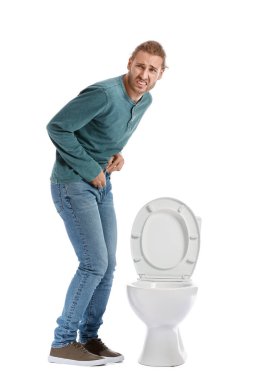 Beyaz arka planda sık sık işeme sorunu olan bir adam. Diyabet belirtileri