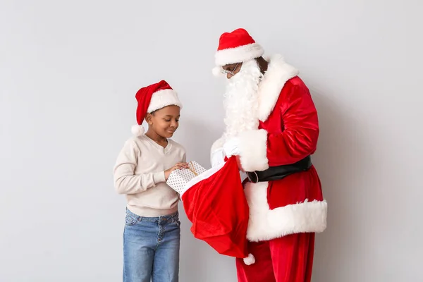 Афро Американский Мальчик Выбирает Подарок Сумки Санта Клауса Светлом Фоне — стоковое фото
