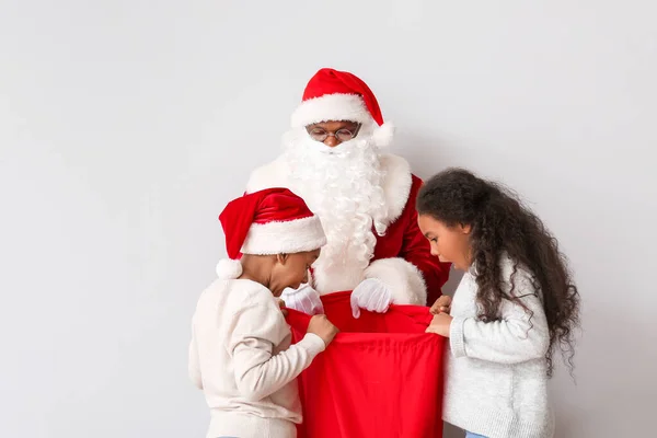 Crianças Afro Americanas Escolhendo Presentes Bolsa Papai Noel Fundo Claro — Fotografia de Stock