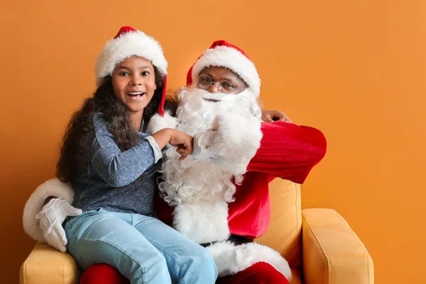 非洲裔美国人圣诞老人 长着可爱的小女孩 在彩色背景下猛击拳头 — 图库照片