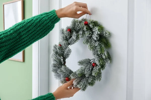 Mujer Colgando Hermosa Corona Navidad Puerta —  Fotos de Stock