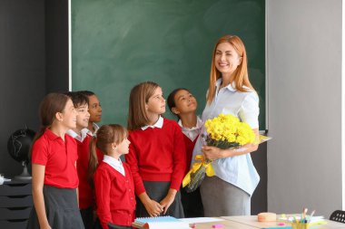 Okul çocukları sınıfta öğretmenlerini selamlıyorlar.