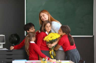 Okul çocukları sınıfta öğretmenlerini selamlıyorlar.