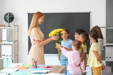 Okul çocukları sınıfta öğretmenlerini selamlıyorlar.
