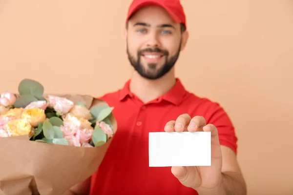 Liefermann Mit Blumenstrauß Und Visitenkarte Auf Farbigem Hintergrund — Stockfoto