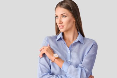 Hafif arka planda kol saati olan genç bir kadın.