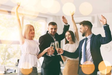 Gençler ofiste şampanya kadehlerini tokuşturuyorlar.