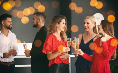 Gençler ofiste şampanya kadehlerini tokuşturuyorlar.