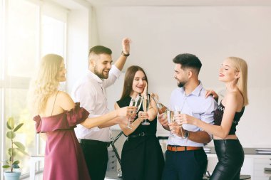 Gençler ofiste şampanya kadehlerini tokuşturuyorlar.