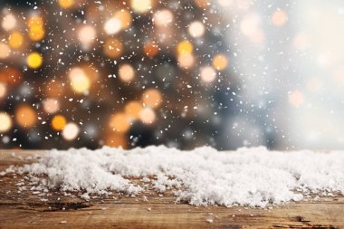 Parlayan Noel ışıklarına karşı karlı ahşap masa manzarası