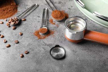 Gri arkaplanda kahve tozu ve fasulye ile Portafilter