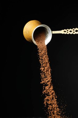 Esmer arka planda kahve tozu olan tencere.