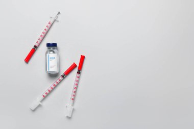 Beyaz arka planda şırıngaları olan bir şişe insülin. Diyabet kavramı