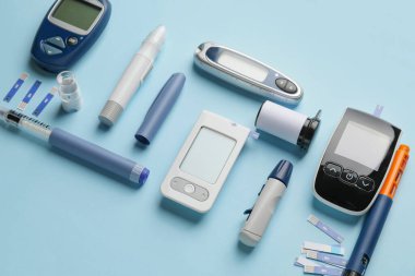Kalemli glukometreler, renkli arka planda test şeritleri ve şırıngalar. Diyabet kavramı