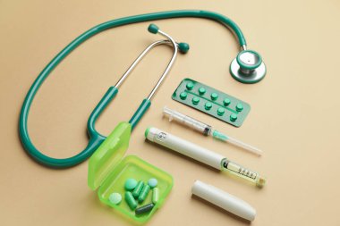 Steteskop, renkli arka planda haplar ve şırıngalar. Diyabet kavramı