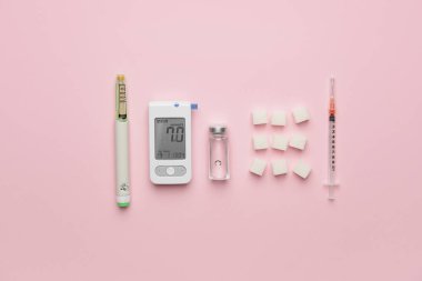 İçinde şeker küpleri, ensülin şişesi ve renkli şırıngalar olan glukometre. Diyabet kavramı