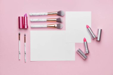 Renk arkaplanında boş kartlar ve makyaj malzemeleriyle kompozisyon