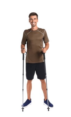 Beyaz arka planda bastonları olan genç bir adam.