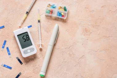 Kalemli glukometre, test şeritleri, şırıngalar ve renkli arka planda haplar. Diyabet kavramı