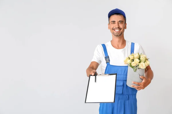 Entrega Hombre Con Ramo Flores Portapapeles Sobre Fondo Claro — Foto de Stock