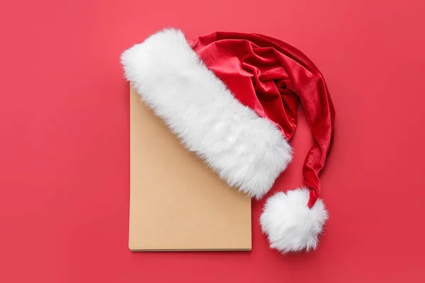 Weihnachtsmütze Und Leere Karte Auf Farbigem Hintergrund — Stockfoto