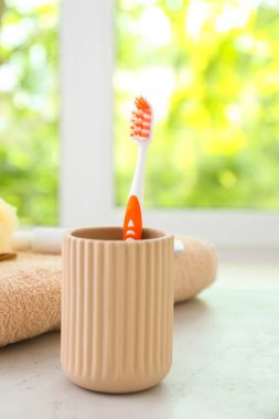 Banyodaki masada diş fırçası olan bir fincan.