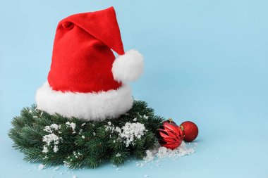 Noel Baba şapkası, arka planda Noel çelengi.