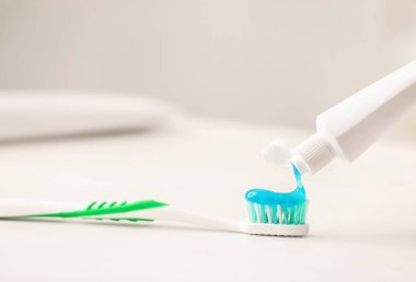 Diş fırçasına yapıştırıcı sıkma, yakın plan.