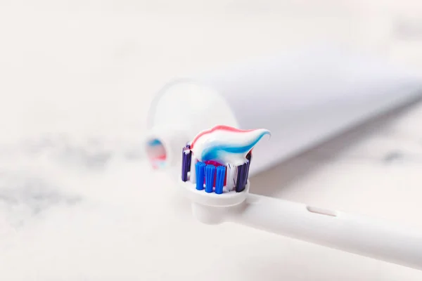 Electric tooth brush with paste on table, closeup