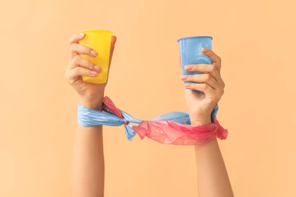 Weibliche Hände Mit Plastikbechern Auf Farbigem Hintergrund Ökologisches Konzept — Stockfoto